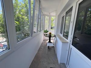 a small table in a room with windows at Lena Apartment in Calafat