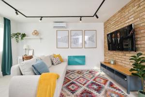 a living room with a couch and a brick wall at Villa Balaton in Balatonmáriafürdő