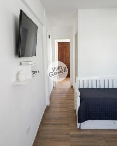 a bedroom with a bed and a tv on a wall at Bright beachfront apartment with ocean view in Villa Gesell