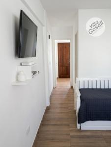 a bedroom with a bed and a flat screen tv on a wall at Bright beachfront apartment with ocean view in Villa Gesell