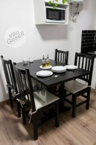 a black dining room table with chairs and a microwave at Bright beachfront apartment with ocean view in Villa Gesell +20 photos