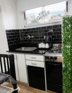 a kitchen with a sink and a stove at Bright beachfront apartment with ocean view in Villa Gesell