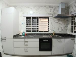 a white kitchen with a sink and a window at The Crest at Oyarifa in Oyarifa