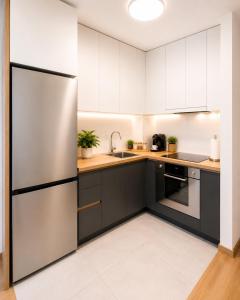 a kitchen with white cabinets and a stainless steel refrigerator at SOLU Luxury Apartments with Free Parking ,Fast Wi -Fi, New Building in Skopje
