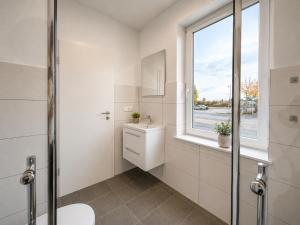 a white bathroom with a toilet and a window at Leipzig Garden Rooms - Near Lake & easy Parking in Leipzig +64 photos