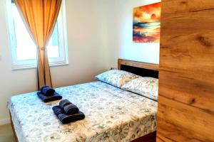 a bedroom with a bed with two towels on it at Luxury Apartment Mara in Sukošan +15 photos