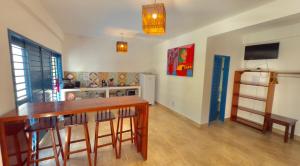 a kitchen with a table and a refrigerator at Casa boa vida in Jericoacoara