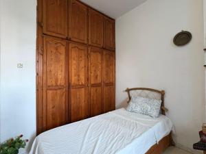 a bedroom with a bed with a wooden headboard at Dar Essadeg in Tataouine