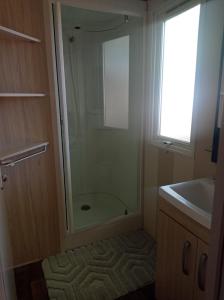 a bathroom with a shower and a sink and a mirror at Mobil home YANN in Sainte-Croix-de-Verdon