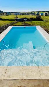 a large swimming pool with blue water in a yard at Casa Otarina Chapadmalal in Chapadmalal