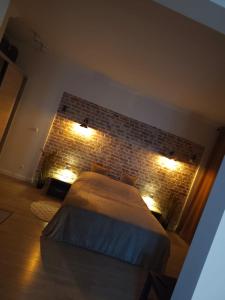 a bedroom with a bed and a brick wall at 1904 Studio in Świnoujście