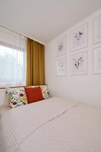 a bedroom with a white bed with pillows and a window at Villa Balaton in Balatonmáriafürdő
