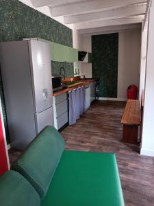 a kitchen with a green table and a refrigerator at Les Marronniers Roses in Châteaulin +7 photos