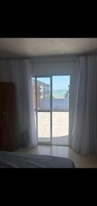 a bedroom with a window with a view of the beach at COBERTURA Duplex 302,vista d Mar e piscina in Piúma
