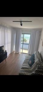 a bedroom with a bed with a view of the ocean at COBERTURA Duplex 302,vista d Mar e piscina in Piúma