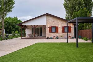 a brick house with a pavilion in a yard at Villa Balaton in Balatonmáriafürdő