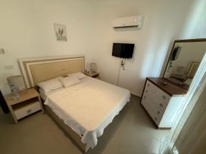 a bedroom with a bed and a dresser and a mirror at Plage Mountain View in El Alamein +13 photos