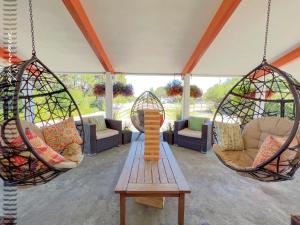 a porch with two hanging chairs and a table at Tide Pool Cabin, a Soquinomere Private Hotel on the Dunes, Downtown Ocean Shores in Ocean Shores