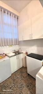 a kitchen with white cabinets and a window at Bascarsija in Ulcinj