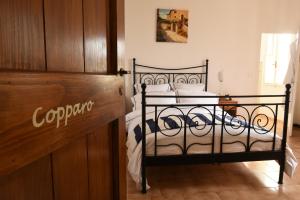 una camera da letto con un letto nero con lenzuola bianche di Via Bruno Rossi 23 ad Ambrogio