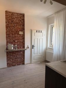 a room with a brick wall and a white door at Altes Lehmhaus Löwenberg in Linde