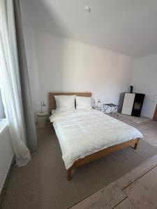 a bedroom with a large bed with white sheets at Altes Lehmhaus Löwenberg in Linde