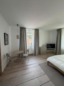 a bedroom with a bed and a table and chairs at Altes Lehmhaus Löwenberg in Linde