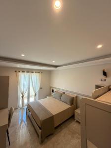 a bedroom with a large bed and a couch at Tropea Olympus Apartments in Santa Domenica