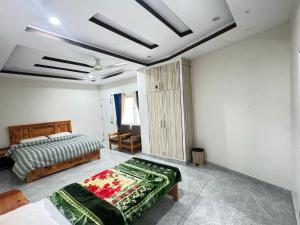 a bedroom with two beds in a room at Ember Guest House in Abbottabad