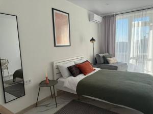 a bedroom with a large bed and a window at Смарт хаус in Yuzhne