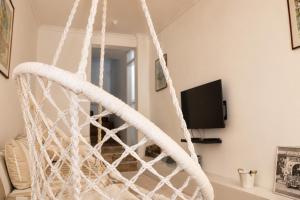 a white rope hanging chair in a living room at Apartman San in Mostar