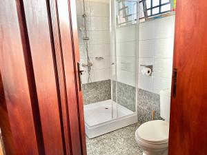 a bathroom with a toilet and a glass shower at El SALI APPARENT,Najjera in Namugongo