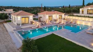 ein Haus mit Swimmingpool im Garten in der Unterkunft Koroni Poolside Suites in Koroni