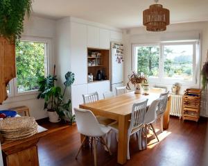 a dining room with a wooden table and white chairs at Villa Pepe, casa compartida in Pontevedra