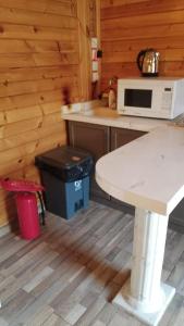 a kitchen with a table and a microwave on a counter at كوخ بحانز الأول in Taif