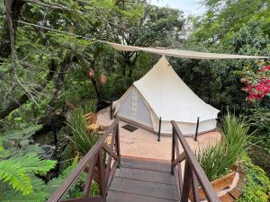 a white tent on a bridge with trees at Glamping en Casa Viento in Tepoztlán