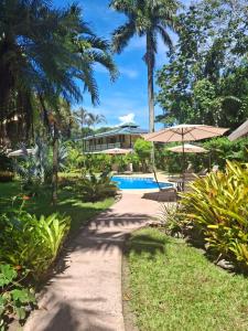 a path leading to a resort with a swimming pool at Playa Negra Guesthouse in Cahuita