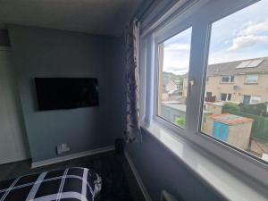 a bedroom with a window with a bed and a television at wyvis stays in Inverness