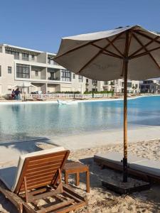 a beach chair and an umbrella on the beach at Plage Mountain View in El Alamein
