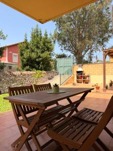 a wooden table and two chairs on a patio at El Jardín de Mer in Miengo