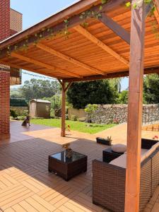 a wooden pergola with a table on a patio at El Jardín de Mer in Miengo
