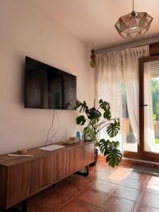 a living room with a tv on the wall at El Jardín de Mer in Miengo