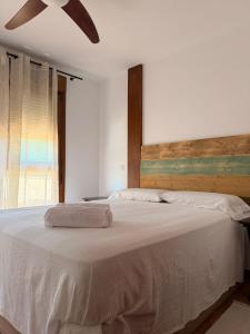 a bedroom with a white bed with a ceiling fan at El Jardín de Mer in Miengo