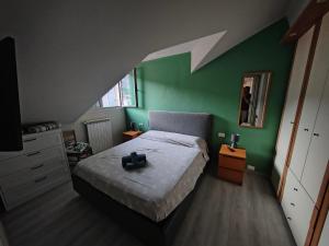 a bedroom with a bed and a green wall at Attico Sole e Mare in Ventimiglia