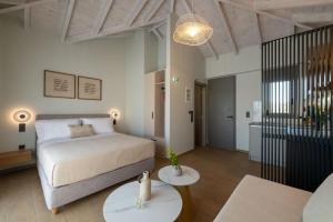 ein Schlafzimmer mit einem Bett und zwei Tischen in der Unterkunft Koroni Poolside Suites in Koroni + 67 Fotos