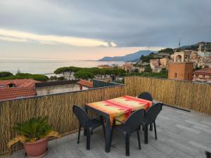 a table and chairs on a balcony with a view at Attico Sole e Mare in Ventimiglia