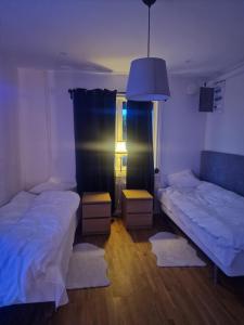 a room with two beds and a lamp and a window at Cosig house in Nygård