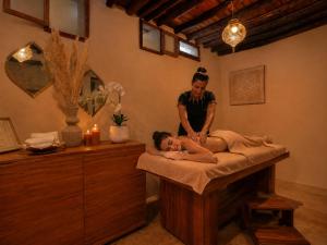 a woman giving a woman a massage in a bed at Riad El Maâti in Rabat