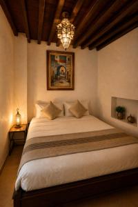 a bedroom with a large white bed with a chandelier at Riad El Maâti in Rabat +62 photos