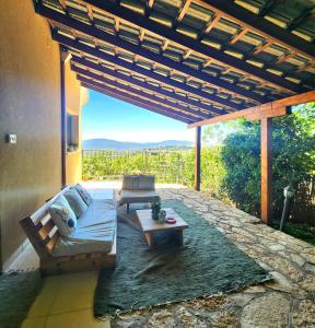 a patio with a couch and a table with a view at קצה ההר in Amirim